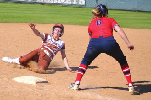 CALDWELL’S EMERSON FAUST slides into third base during the Lady Hornet’s 8-8 tie with Madisonville on Saturday during the annual SWARM Tournament at Lady Hornet Field in Caldwell.