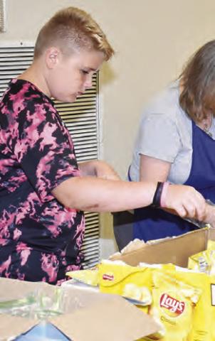 VOLUNTEERS WORK in the serving line at the fundraiser for New Tabor Brethren Church on Saturday at the Expo Center.