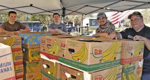 IN GOD’S HANDS Ministry prepares these food boxes on Saturday, Nov. 22, for distribution. Pictured are, from left, Drew Davidson, Joshua Thornton, Steven Joodin and David Palicka.