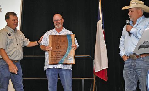 POSGCD BOARD PRESIDENT Jay Wilder is presented this plaque for his 20 years of service on the board by POSGCD General Manager Gary Westbrook, left, and Burleson County Judge Keith Schroeder.