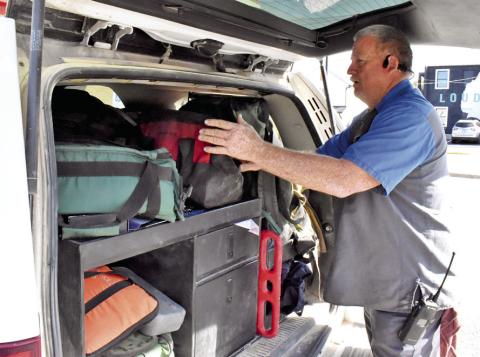 CALDWELL AND CADE Lake Fire Chief David Pevehouse looks over his gear at the Caldwell Fire Station on Main Street. Tribune photo by Roy Sanders