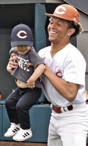 KORBIN BURNS holds this future Hornet during Little League Day at Hornet Field. Tribune photo by Roy Sanders