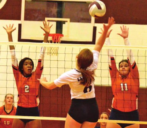 CALDWELL’S AALIYAH MASSINGILL and Addison Reed reach to attempt to block a hit by Cameron Yoe’s Haley Tucker during the Lady Hornets’ win on Friday. -- Tribune photo by Roy Sanders