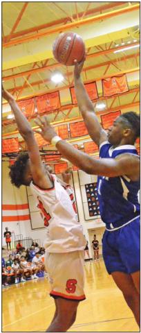 SNOOK’S QWAN YOUNG makes the go-ahead points to make it 48-47 as Dominic Tucker of Somerville defends. The teams battled into overtime with Snook winning 50-49. -- Tribune photo by Roy Sanders