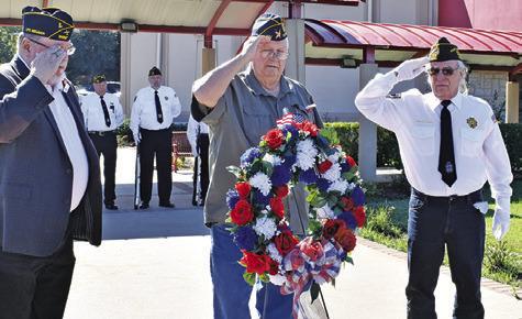VETERANS SALUTE AS the wreath is placed at the Veterans Memorial at the Caldwell Civic Center. They include, from left, John Mayson, DAV, Donny Wood, American Legion, and Henry Probst, VFW.