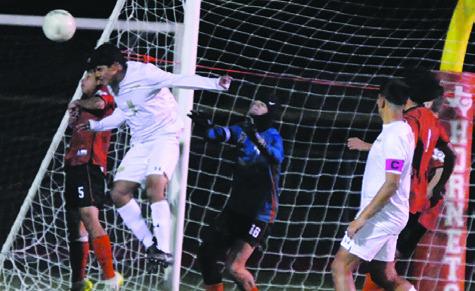A GIDDINGS’ PLAYER HEADS the ball while the Caldwell goalkeeper keeps a close eye on the direction of the ball in the air during the Hornets’ 5-0 loss to the Buffaloes last Friday night at Hornet Field. Tribune photo by Denise Squier