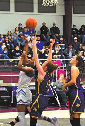 SNOOK’S JAIVAN STRINGFELLOW puts up a layup while Shiner’s Emma Herman defends during the Lady Jays’ area win over the Lady Comanches. -- Photo courtesy of Mark Lube of The Shiner Gazette