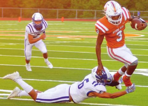DONTAVIAN JOHNSON CARRIES the ball for Caldwell as Snook’s Jose Garcia defends. Caldwell held on last Friday at Hornet Stadium for a close victory 28-26. -- Tribune photo by Roy Sanders