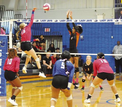 SNOOK’S DAKOTA KIENOW GETS one of her five kills while Somerville’s Karys Ellis attempts a block during the Snook-Somerville rivalry match last Tuesday night in Snook. Tribune photo by Denise Squier