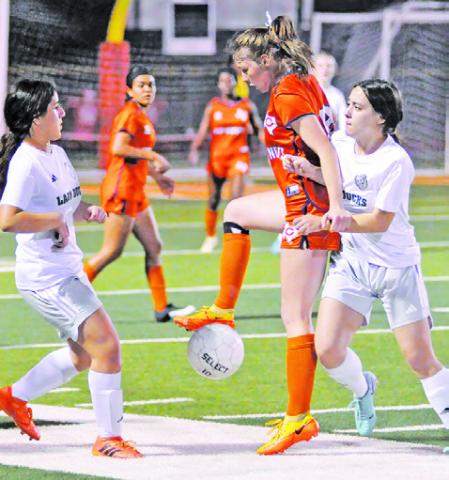 CALDWELL SENIOR AND TEAM captain Cadie Coston is challenged by two Taylor players during the Lady Hornets’ final district game this season at Hornet Field. -- Tribune photo by Denise Squier