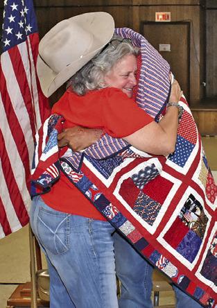 SHARON COLLEY hugs Robert Norris after he receives his Quilt of Valor at the VFW.