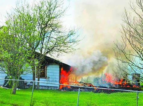 THIS HOUSE ON County Road 349 burns as firefighters arrive. Photo courtesy of Snook Volunteer Fire Department
