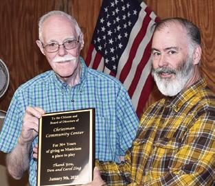 DON LING presents a plaque to Sam Johnson of the Chriesman Community Center honoring the center’s long-time support of live music. The plaque was presented on behalf of the musicians at the center’s Jan. 16 board meeting. Tribune photo by Roy Sanders