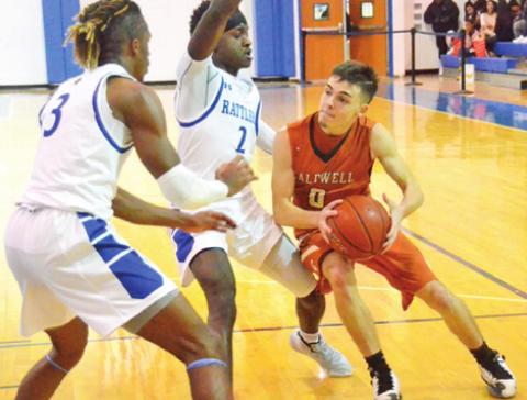 CALDWELL’S BOBBY LEROUAX dribbles the ball around these Navasota defenders last Friday in Navasota. The Hornets lost 53-41 and were to face Giddings on Tuesday in Caldwell.