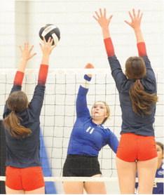 SNOOK’S AUBREY BECKER HITS the ball between two Madisonville blockers during the Navasota Varsity Volleyball Tournament last Thursday and Saturday. -- Tribune photo by Denise Squier