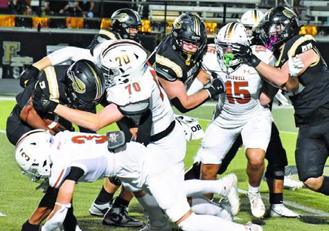 THE HORNET DEFENSE led by R.J. King, Caden Schluens and Josh Wilson move in on this Giddings ball carrier last Friday. Tribune photo by Roy Sanders