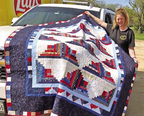 CREATIVE MEMORIES QUILT Guild donated this quilt to the Cade Lake VFD for their Annual Barbecue Fundraiser on March 10. Pictured is Melissa Triplett picking up the quilt.