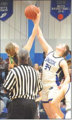 ALEXIS MACIK REACHES to hit the ball to a teammate during the opening tip-off of the Snook-Iola game. -- Tribune photo by Denise Squier