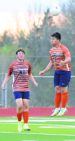 CALDWELL’S NAM LE HEADS the ball during the Hornets’ final game of the season against Taylor. Reese Simpson looks on. For more about the game, see story inside. -- Tribune photo by Denise Squier