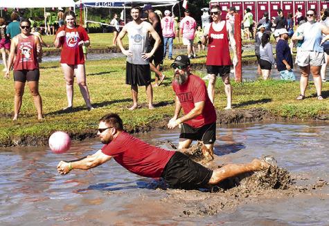 A MUD VOLLEYBALL player lunges for the ball right before he falls into a big mess.