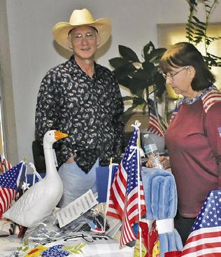 AUCTION ITEMS are displayed and viewed on Saturday at the July 4 celebration at the Hermann Sons Life Hall in Deanville.