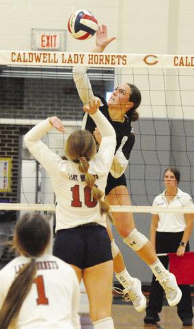 GIDDINGS’ FAITH ZOCH gets a kill against the Lady Hornets while Caldwell’s Kelly Urbanovsky attempts a block during the Lady Buffs’ straightset district victory at Hornet Gym in Caldwell on Friday. Also pictured is Brooklyn Snider. -- Tribune photo by Denise Squier