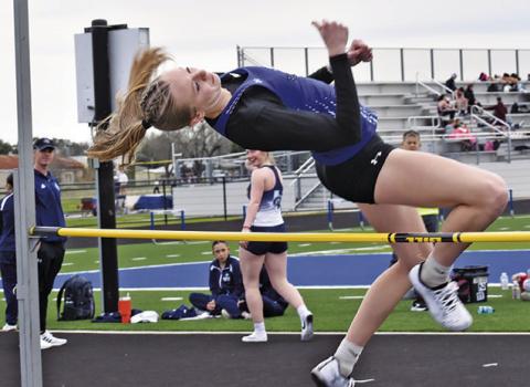 DAKOTA KIENOW LEAPS in the varsity girls high jump at last week’s Bluejay Relays. Tribune photo by Roy Sanders