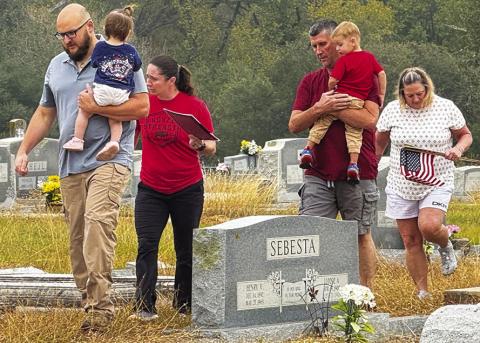 ENTIRE FAMILIES PARTICIPATED in placing U.S. flags on veterans’ graves in the Snook Cemetery on Saturday morning, in observance of Veterans Day. Tribune photo by Denise Squier