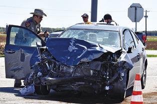 A DPS TROOPER works the site of this car-pickup collision on Sunday afternoon, March 16, at the F.M. 50 and F.M. 60 intersection. No details were available at press time. Tribune photo by Roy Sanders