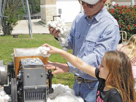DALE MOTT demonstrates how a cotton gin separates raw cotton into cotton lint and seed during the Burleson County Czech Heritage Museum’s Heritage Day on Saturday in Caldwell.