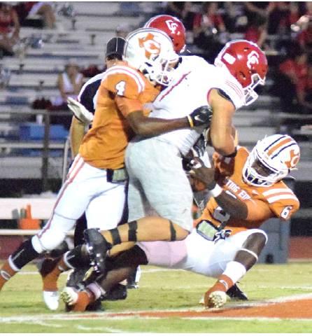 CALDWELL’S DONTAVIAN JOHNSON and Nicolas Johnson tackle the Columbus player after a big yardage gain for the Cardinals in the first half of Friday night’s game. -- Tribune photo by Denise Hornaday