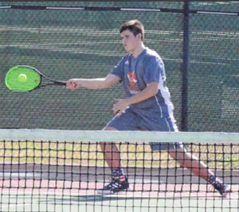 CONNOR HUGHSON returns serve during his first round boys doubles match at the Bastrop Winter Cup Varsity Tennis Tournament last Friday. -- Tribune photo by Denise Squier