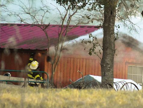 FIREFIGHTERS WORK THE scene of this fire on SH 36 North.