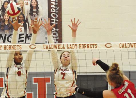 TYNIAH JOHNSON AND LYDIA Giese attempt to block a hit from BVCHEA’s Cali Engram during the Lady Hornets’ match against the Lady Mustangs on Friday night in Hornet Gym. Tribune photo by Denise Squier