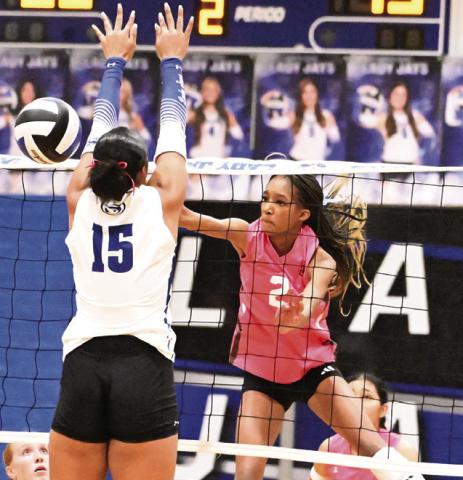 SOMERVILLE KARYS ELLIS GETS the ball past the attempted block from Snook’s Teyana Nickerson for a kill during the Snook-Somerville rival match last Friday at the Snook High School Gym. Tribune photo by Denise Squier