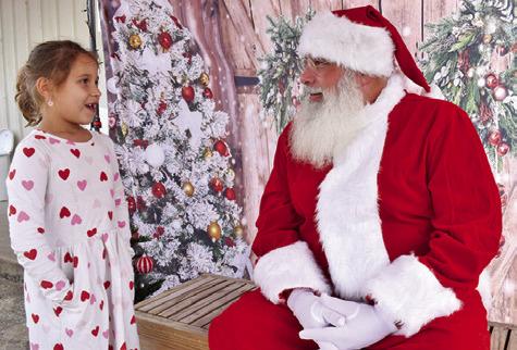 SANTA CLAUS VISITS with a girl on Sunday morning at the Farmers Market in Somerville. The Christmas theme was enjoyed by visitors.
