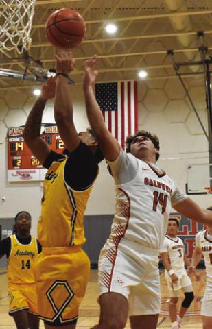 JOHN FRYREAR of Caldwell reaches high for this rebound against Academy Tribune photo by Roy Sanders