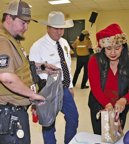 SHERIFF BILL RIOS and his wife Irma help with presents during Shop With A Cop.