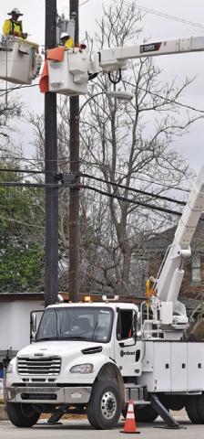 ARDENT SERVICES crew members work on these electrical lines in Hill Street. Tribune photo by Roy Sanders