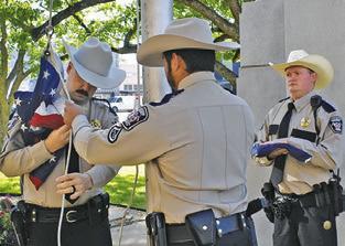 BURLESON COUNTY Sheriff’s Sgt. Chase Welch, and Deputies Steven Guerrero and Jonathan Weichert raise the flags.