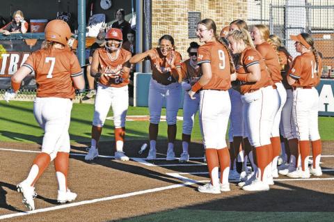 CALDWELL’S EMILY SMITH IS GREETED by the rest of the Lady Hornets at home plate after her home run during the Lady Hornets’ 14-0 win over Smithville on Friday. -- Tribune photo by Roy Sanders