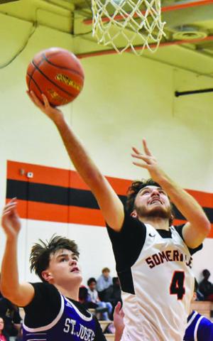KASON ROHRBACH moves past this St. Joseph defender for a layup shot. Tribune photo by Roy Sanders