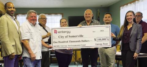 SOMERVILLE CITY OFFICIALS ACCEPT this check for grant funding from Entergy at their Aug. 20 meeting. Pictured are, from left, Kenny Muhammad, regional customer service manager, Alderman Mark Sager, Alderman Delfino Orozco, Alderwoman Laura Hoover, Mayor Tommy Thompson, City Administrator Danny Segundo, Melissa Bochat, Entergy customer service manager, and new City Administrator David Resendiz.