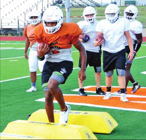 CALDWELL’S CADARIUS WILLIAMS carries the ball on this drill on Monday during the Hornets’ workout. -- Tribune photo by Roy Sanders