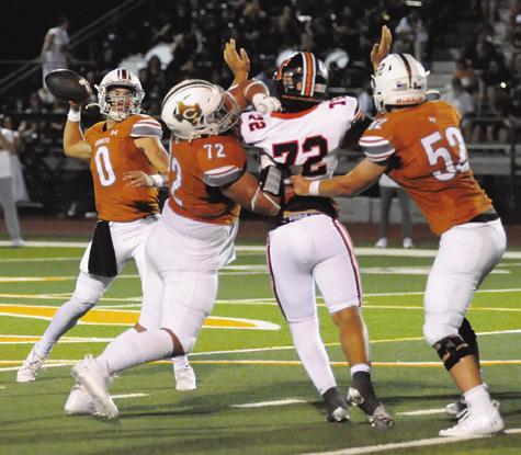 CALDWELL’S COY BECKA passes against Smithville while Preston Supak and Chase Clark block. Caldwell won 49-24. Tribune photo by Denise Squier