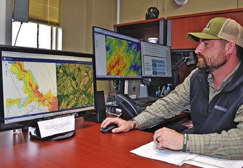 BURLESON COUNTY EMERGENCY Management Coordinator Ty Eller looks at these area maps in his office at the courthouse. Tribune photo by Roy Sanders