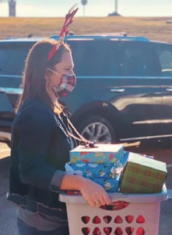 NICKI DRGAC, Caldwell Intermediate School counselor, loads gifts into a vehicle to be delivered to area families. Over 400 gifts were given to 90 Caldwell ISD children and their families through Hornets Helping Hornets.