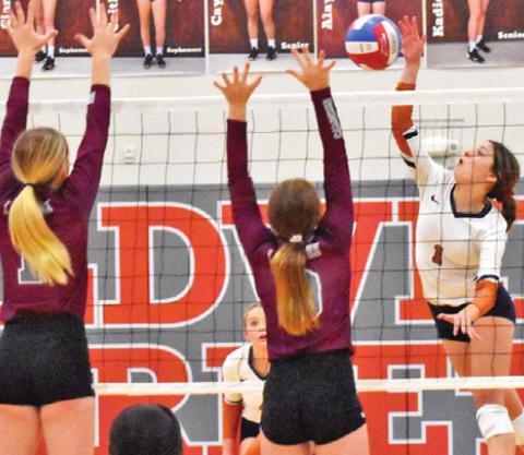 CALDWELL’S ASHLYN KELLUM hits the ball over two blockers last Friday during the Lady Hornets’ district loss to Cameron Yoe.