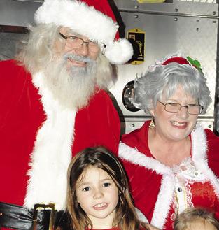 SANTA AND MRS. Claus took time out to pose with area children for photos during last year’s Christmas on the Square.