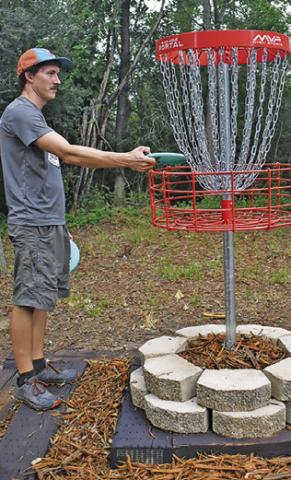 DUSTIN SANFORD works on Monday at Caldwell’s expanded disc golf course.
